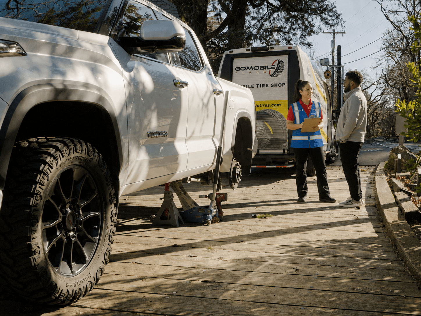 GoMobile technician consulting with a customer beside a mobile tire service truck